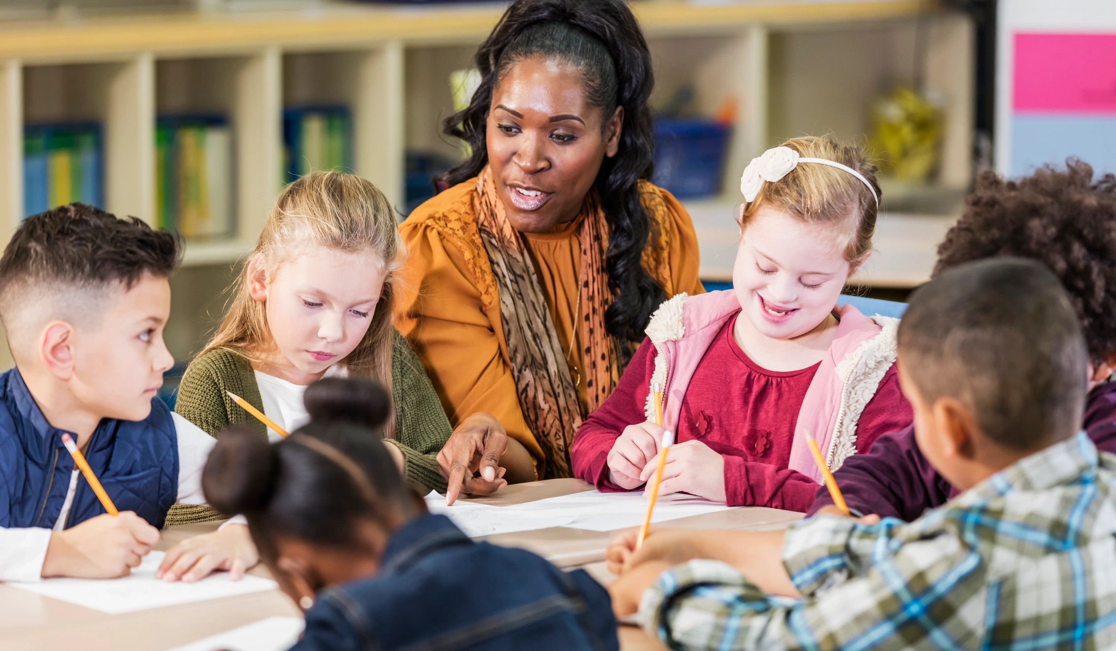 Teacher guiding children during a table activity